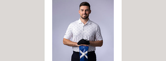 Male golfer wearing a Glenmuir white, flag print golf polo shirt