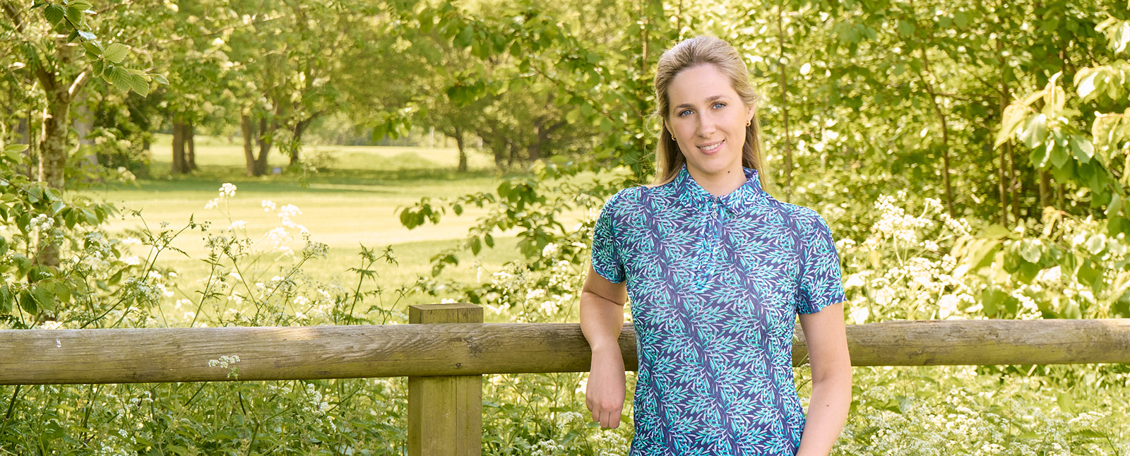 Woman wearing Pure Golf Ocean Aura short sleeve mesh print polo available at GolfGarb.