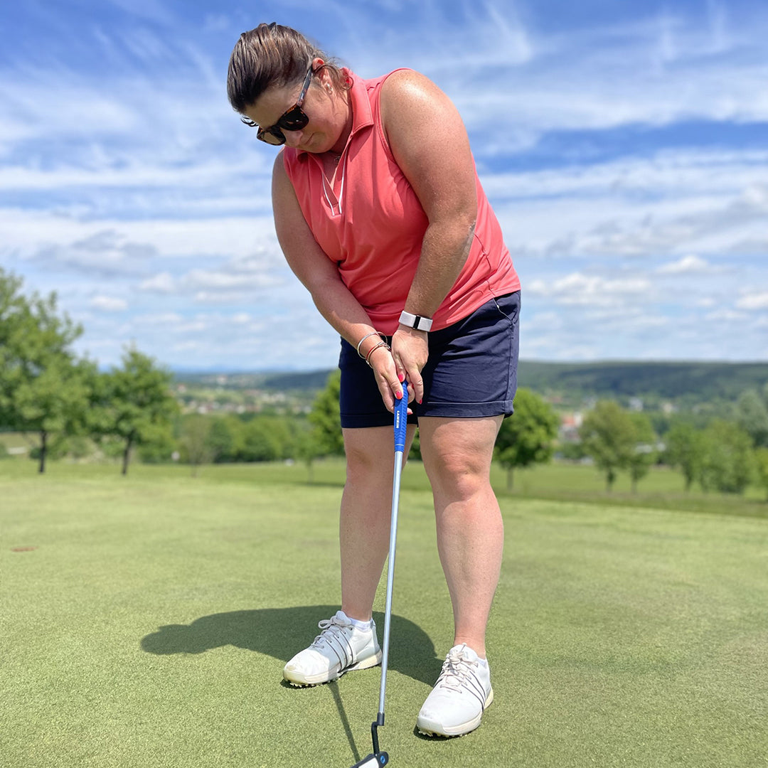 Professional Golfer Sarah Gee putting in the Puma Golf ladies sleeveless open v neck polo shirt in peach frost available at GolfGarb